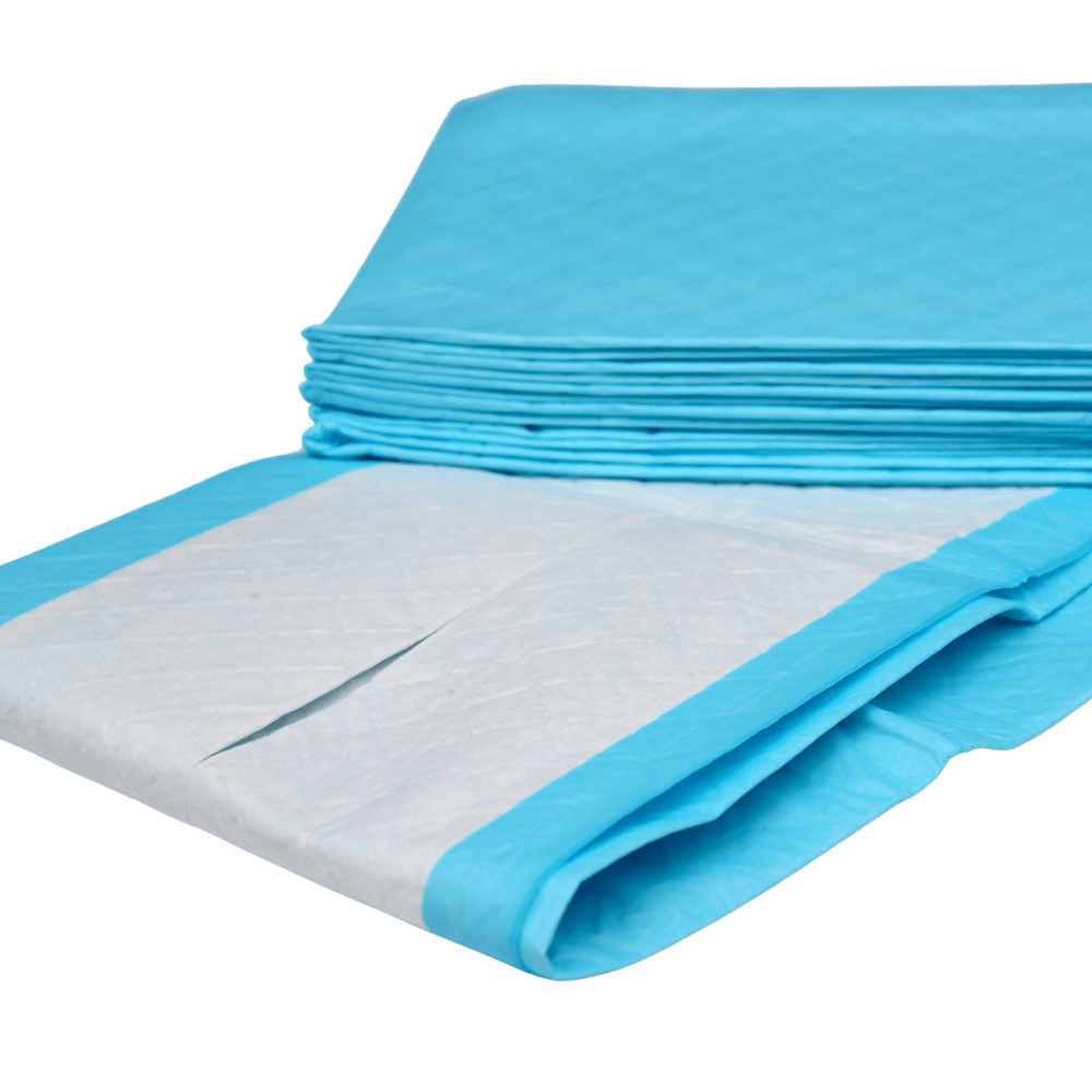 Na zdjęciu widoczny jest stos niebieskich podkładek ochronnych Altruflock® o wymiarach 60 x 90 cm, typu „Supersoft” o wyjątkowej chłonności | opakowanie (25 sztuk) firmy Altruan, przeznaczonych do jednorazowego użytku. Jedna z podkładek jest częściowo rozłożona, dzięki czemu widoczna jest biała, chłonna powierzchnia z niebieskimi brzegami. Podkładki na nietrzymanie moczu wydają się być ułożone w równy stos.