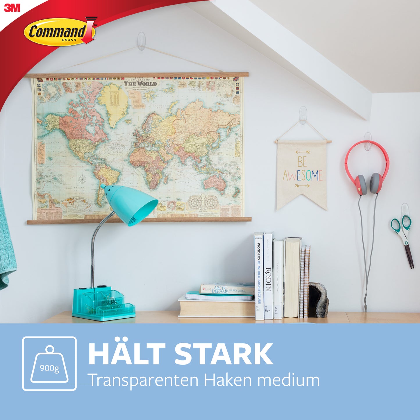 In einem hellen Raum hängen eine Weltkarte, ein "Be Awesome"-Schild und Kopfhörer an einem 3M Deutschland GmbH Command™ Haken M, mittelgroß, transparent (17091CLR), über einem Schreibtisch mit blauer Lampe und Büchern. Deutscher Text: "Hält stark. Rückstandsfrei. Transparenten Haken mittelgroß.