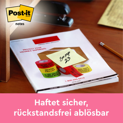 Notatka Post-it® firmy 3M Deutschland GmbH w kolorze żółtym (38 x 51 mm, 100 kartek/blok) z napisem "Zobacz stronę 23" leży na papierze na biurku. Na dole napis: "Pewnie się przyczepia, łatwo odrywa bez śladów." Certyfikowane przez PEFC, kartonowe opakowanie.