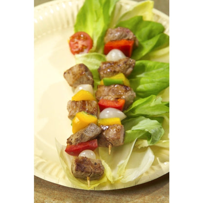 Szaszłyk z grillowanym mięsem, papryką, pomidorami i cebulą spoczywa na beżowym talerzu sałatkowym, serwowany z PAPSTAR szaszłykowymi patyczkami drewnianymi "pure" Ø 3 mm, 20 cm (1000 sztuk) firmy PAPSTAR GmbH dla ekologicznego akcentu.