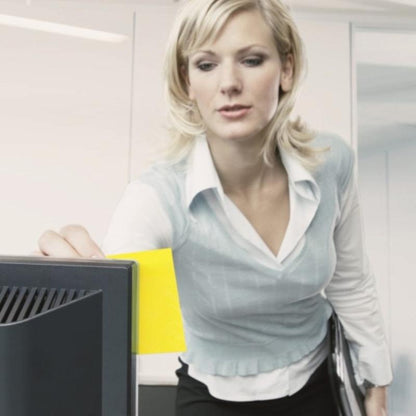 Bizneswoman w nowoczesnym biurze przykleja kostkę notatek samoprzylepnych Post-it® 636-B, żółtą, 76 mm x 76 mm, od 3M Deutschland GmbH na swój monitor, trzymając jednocześnie dokumenty. Samoprzylepne karteczki służą jako pomoc w przypominaniu.