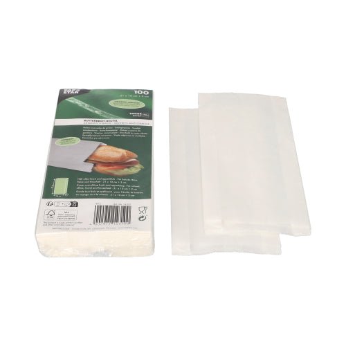 Stos białych PAPSTAR torebek na kanapki odpornych na tłuszcz (21x10x3 cm) jest pokazany obok zielono-białego opakowania PAPSTAR GmbH, które przedstawia kanapkę i informacje o produkcie. Obok opakowania (100 sztuk) znajduje się kilka torebek z folii termokurczliwej, częściowo rozłożonych.