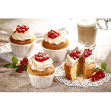 In PAPSTAR GmbH Muffins-Backförmchen Ø 5 cm, 3,5 cm hoch, weiß (20 Stück) sitzen vier Cupcakes mit weißem Zuckerguss und roten Beeren auf einer Arbeitsplatte. Eines ist aufgeschnitten. Im Hintergrund sind ein Minzezweig und ein Latte-Glas zu sehen.