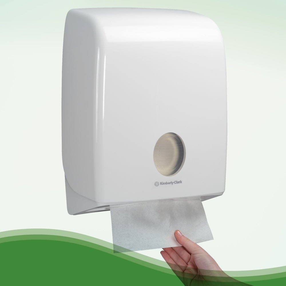 Ręka wyciąga ręcznik Hostess™ NATURA™ biały od Kimberly-Clark GmbH z zamontowanego na ścianie dozownika z białą plastikową pokrywą i okienkiem - idealny do publicznych toalet. 20 klipsów x 84 arkusze/karton.