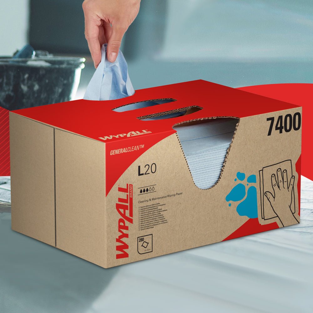 Ręka wyciąga ściereczkę WypAll® L20 General Clean z niebieskiego pudełka BRAG™ firmy Kimberly-Clark GmbH, które zawiera 280 arkuszy, i kładzie ją na gładkiej powierzchni.