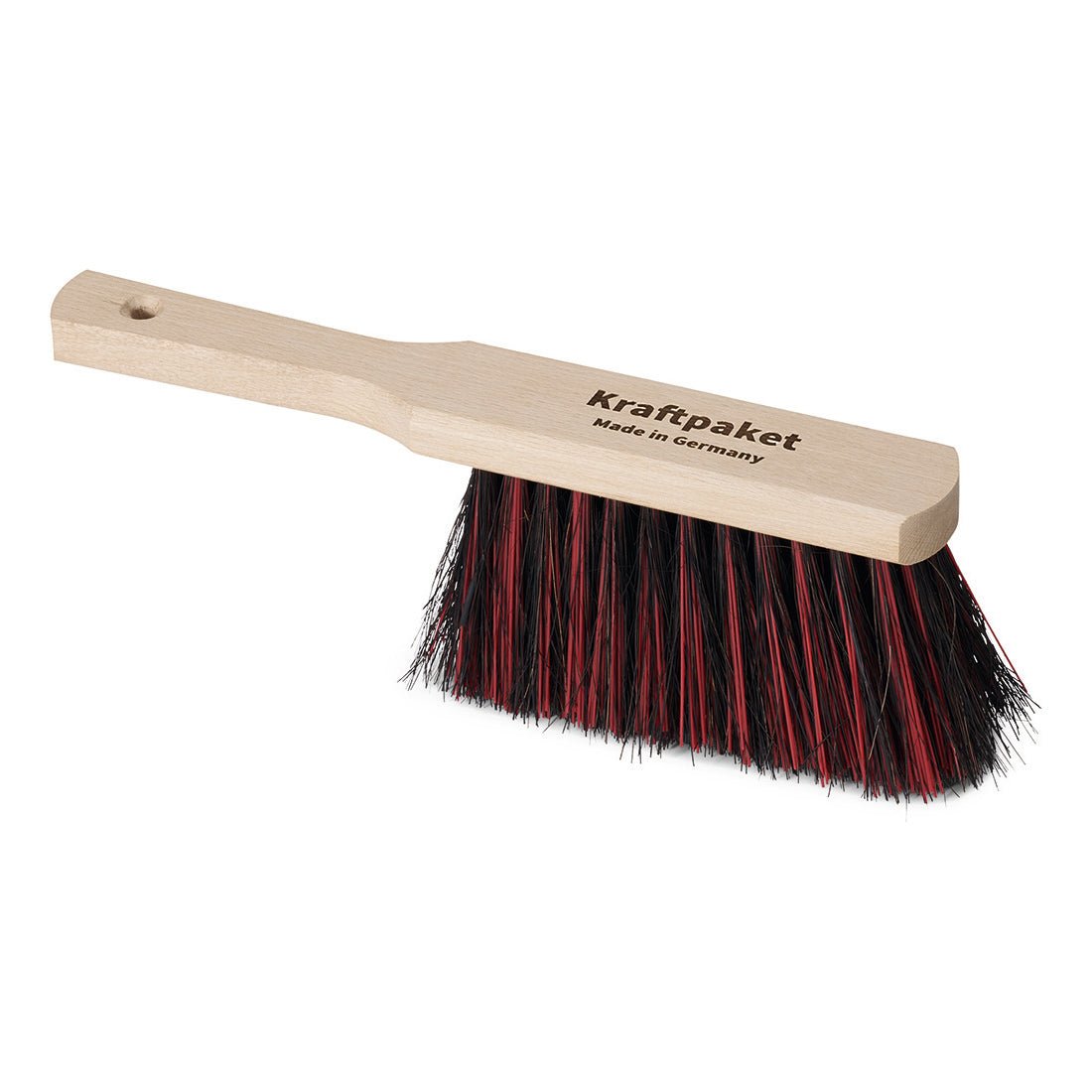 Ręczny zmiatacz Nölle Profi Brush 30 cm z Arenga/Elaston od Nölle Profi Brush Bürsten- & Pinseltechnik e.K. ma jasny drewniany trzonek z napisem "Kraftpaket Made in Germany" i czarno/czerwone włosie, przedstawiony na białym tle.