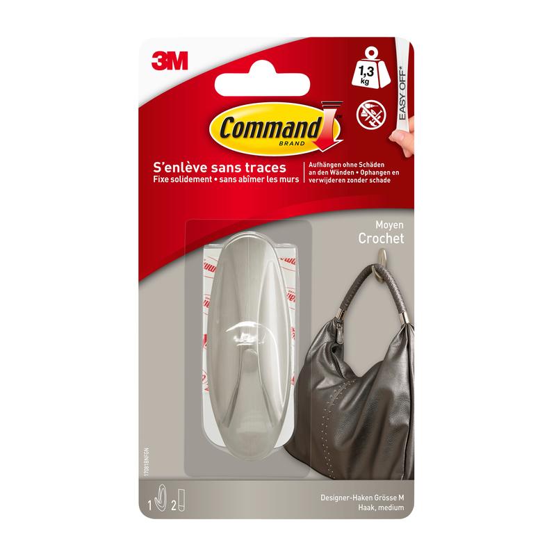 Opakowanie wieszaka Command™ Medium Designer w metalicznym wyglądzie (17081BN) od 3M Deutschland GmbH pokazuje solidny wieszak, który trzyma torebkę. Według opakowania utrzymuje do 1,3 kg i można go czysto usunąć, nie pozostawiając śladów.