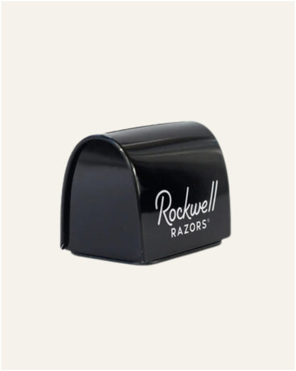 Ein modernes Badezimmer verfügt über einen runden Spiegel, ein weißes Gefäßwaschbecken, einen schwarzen Wasserhahn und den Scott® Control™ Schaum-Handreiniger (4 Kartuschen) von Kimberly-Clark GmbH für optimale Handhygiene. Neben dem Waschbecken steht eine Vase mit grünen Blättern, rechts daneben befindet sich ein Warmwasserbereiter.