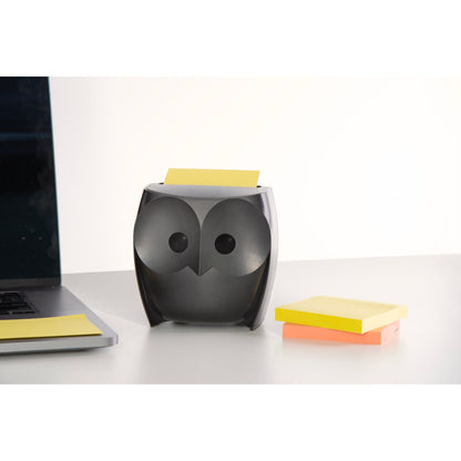 3M Post-it® Z-Notes Dispenser w kształcie sowy, czarny, trzyma żółte Super Sticky Z-Notes. Obok leżą zamknięty laptop i opakowanie z żółtymi i różowymi Z-Notes (2 bloki po 45 arkuszy) na białym biurku.