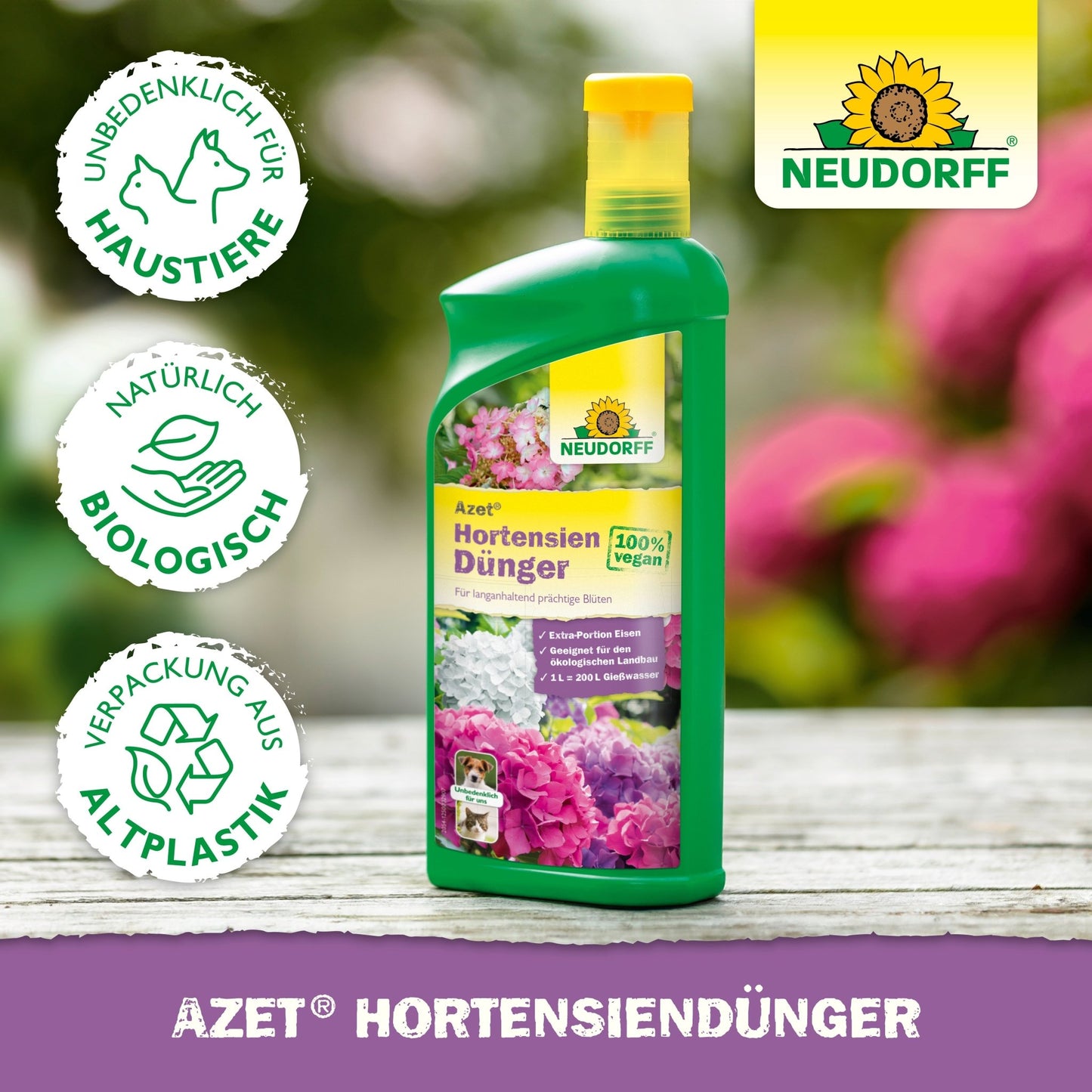 Zielona butelka płynnego nawozu do hortensji Neudorff Shop Azet z obrazkami kwiatów na etykiecie, przedstawiona z symbolami bezpieczny dla zwierząt, nawóz organiczny i bioplastik. Tło pokazuje rozmyte kwiaty.
