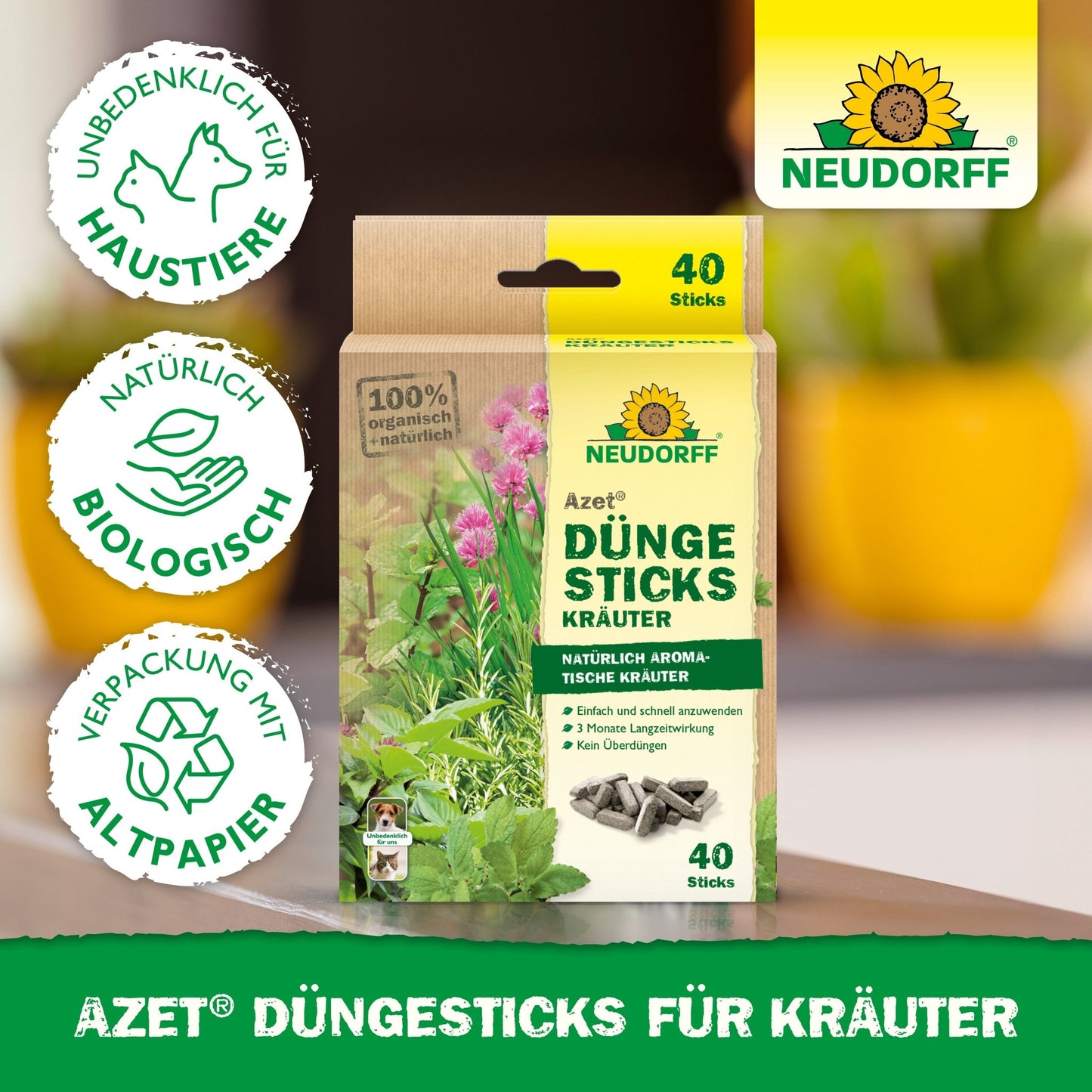 Azet Düngesticks dla ziół ze sklepu Neudorff z 40 ekologicznymi pałeczkami w przyjaznym dla zwierząt, nadającym się do recyklingu opakowaniu są przedstawione. Etykieta jest widoczna, w tle widoczne są zielone rośliny i ziemia kwiatowa.
