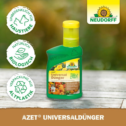 Zielona butelka Neudorff Shop Azet UniversalDünger płynny z żółtą nakrętką spoczywa na drewnie. Na etykiecie przedstawione są owoce, warzywa i rośliny oraz symbole bezpieczeństwa dla zwierząt domowych, biologicznych składników i opakowań z recyklingu.