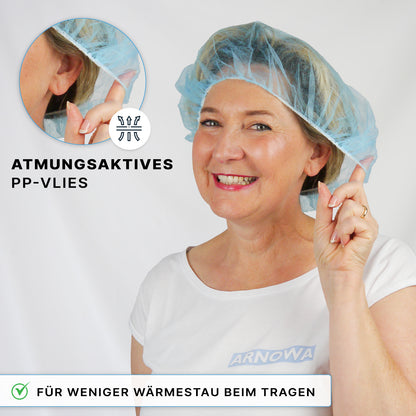 Eine Frau lächelt in einer blauen ARNOMED COVER PP-BARETTHAUBE der ARNOWA GmbH und zeigt auf das atmungsaktive PP-Vlies mit den Aufschriften "atmungsaktives PP-Vlies" und "hitzereduziert - ideal für den Hygienebereich".