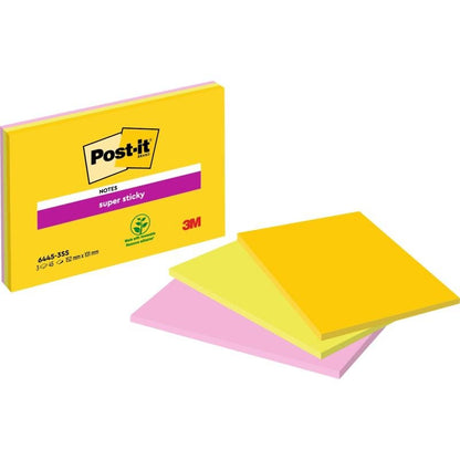 Opakowanie dużych karteczek samoprzylepnych Post-it® Super Sticky Notes od 3M Deutschland GmbH leży obok trzech stosów żółtych i różowych karteczek. Opakowanie pokazuje logo 3M, symbol kleju na bazie roślin i 100% PEFC.