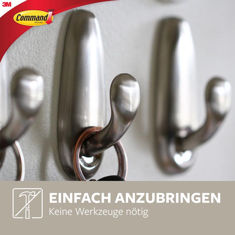Zbliżenie metalowego haka Command™ "klasycznego" firmy 3M Deutschland GmbH z pierścieniem na klucze na haku. Zawiera logo i niemiecki tekst: "Łatwy w montażu. Nie są potrzebne narzędzia." (Łatwy w montażu. Nie są potrzebne narzędzia).
