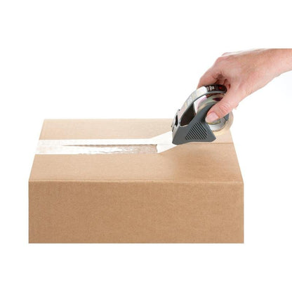 Ręka zamyka brązowy karton nad górnym szwem taśmą pakową Scotch® Box Lock™ 48 mm x 20,3 m od 3M Deutschland GmbH z podajnikiem taśmy, wszystko na białym tle.