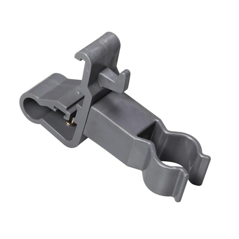 Uchwyt akcesoriów TASKI firmy Diversey Deutschland GmbH & Co. OHG to szara klamra z tworzywa sztucznego z dwoma okrągłymi otworami i zawiasem blokującym. Służy do bezpiecznego mocowania cylindrycznych narzędzi czyszczących i organizacji akcesoriów czyszczących. Gładka powierzchnia, kątowe detale.