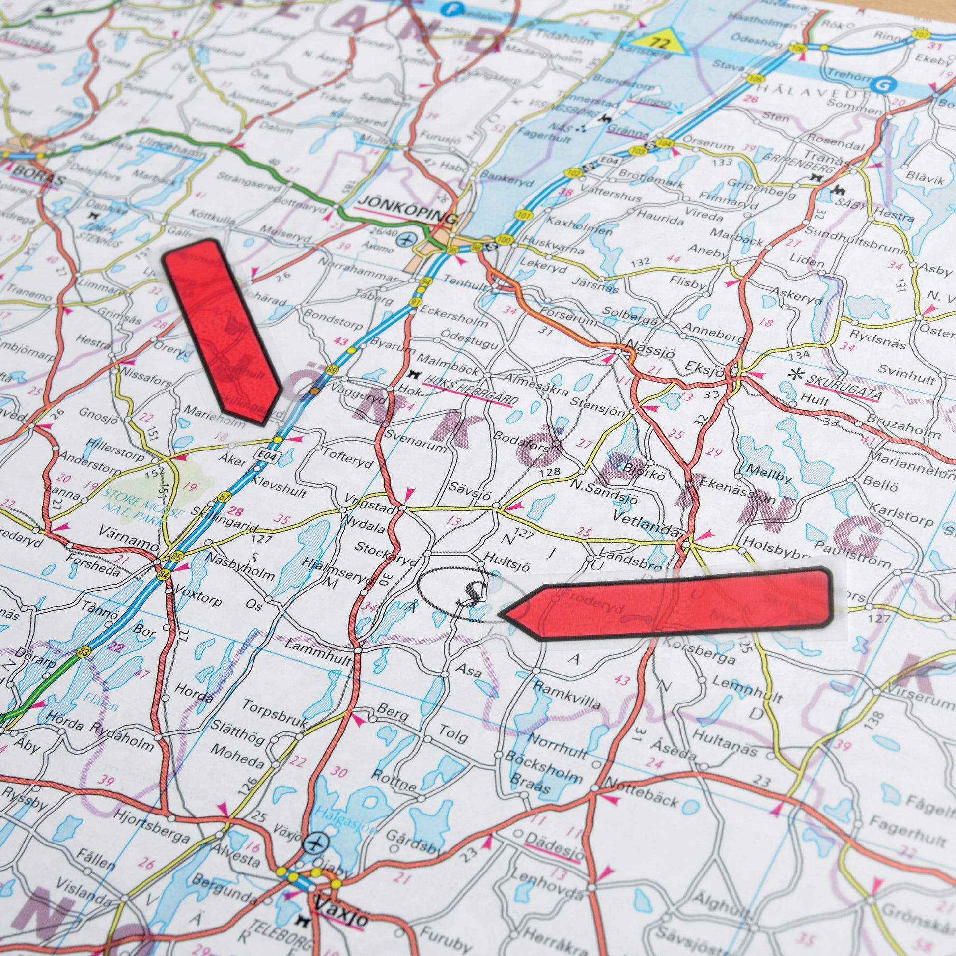 Eine Nahaufnahme einer Papierkarte mit zwei großen roten Post-it® Index Pfeilen (3M Deutschland GmbH, 11,9 mm x 43,2 mm), die verschiedene Orte in der Nähe von Jönköping, Schweden, markieren.