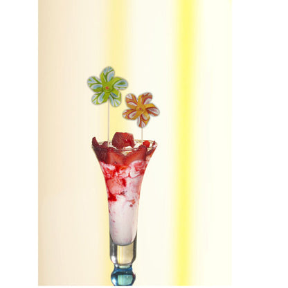 Wysoka szklanka zawiera różowo-biały deser, zwieńczony sosem truskawkowym i PAPSTAR dekoracyjną szpilką "Wiatrak" (17,5 cm, sortowane kolorystycznie), która w zabawny sposób wzbogaca dekorację imprezy. Zestaw firmy PAPSTAR GmbH zawiera 50 szpilek w kartonowej tacy.