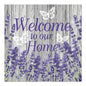 Schild mit violettem Text "Welcome to our Home" auf grauem Holzhintergrund, verziert mit lavendelfarbenen Blumen und drei weißen Schmetterlingen, in Anlehnung an PAPSTAR 20 Servietten, 33x33cm, 3-lagig von PAPSTAR GmbH.