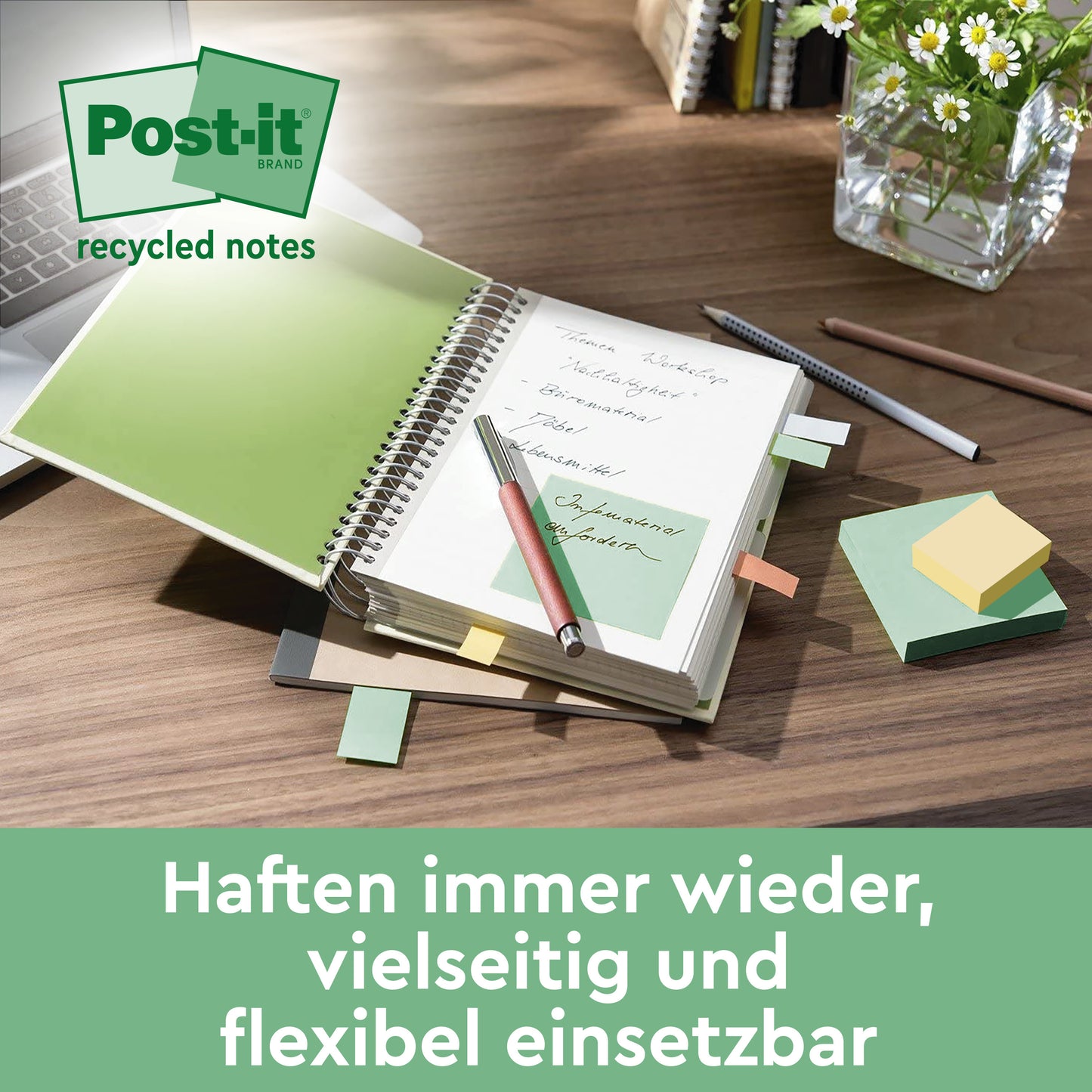 Biurko z otwartym notatnikiem z zielonymi Post-it® Recycling Notes (76 mm x 127 mm, 100 arkuszy/blok, 100% PEFC) od 3M Deutschland GmbH, długopisem, różnokolorowymi karteczkami Post-it®, klawiaturą, szklaną wazą z roślinami i niemieckim tekstem na dole.