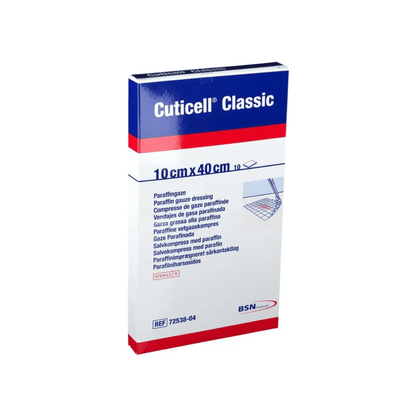 Obraz przedstawia opakowanie BSN Cuticell® Classic sterylna kompresja maściowa z parafiną firmy BSN Medical GmbH. Opakowanie jest białe z niebieskim i czerwonym tekstem, mierzy 10 cm x 40 cm i zawiera wielojęzyczne opisy oraz logo BSN Medical, co czyni je idealnym do pielęgnacji ran.