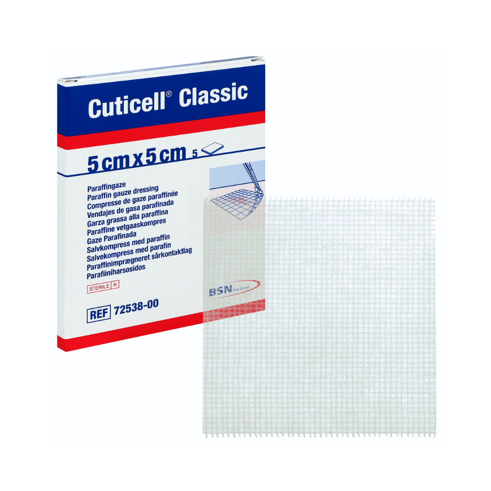 Obraz przedstawia prostokątne pudełko z napisem „BSN Cuticell® Classic sterylna kompresja maściowa z parafiną” firmy BSN Medical GmbH, o wymiarach 5 cm x 5 cm i ilości opakowania 5 sztuk. Tekst zawiera termin „gazik parafinowy” w kilku językach, co wskazuje, że jest nasączony miękką parafiną. Przed pudełkiem znajduje się kwadratowy kawałek białej gazy, idealny do sączenia ran.