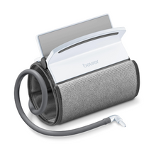 Uniwersalny mankiet do ciśnieniomierza BM 51 Beurer z podłączonym białym monitorem cyfrowym. Od uniwersalnego mankietu odchodzi elastyczny wąż, który kończy się złączem służącym do podłączenia do urządzenia pomiarowego. Lekko pochylony ekran monitora jest częściowo widoczny. Pasuje na obwody ramienia od 22 do 42 cm.