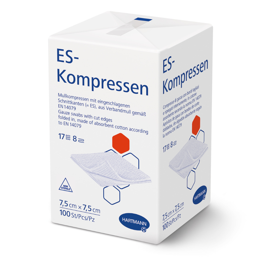 Białe pudełko z napisem "Hartmann ES-Kompressen różnych rozmiarów, niesterylne" firmy Paul Hartmann AG pokazuje informacje o produkcie w języku niemieckim, wymiary 7,5 x 7,5 cm, 100 sztuk, ilustrację kompresów z gazy do pielęgnacji ran oraz logo Hartmann na dole.