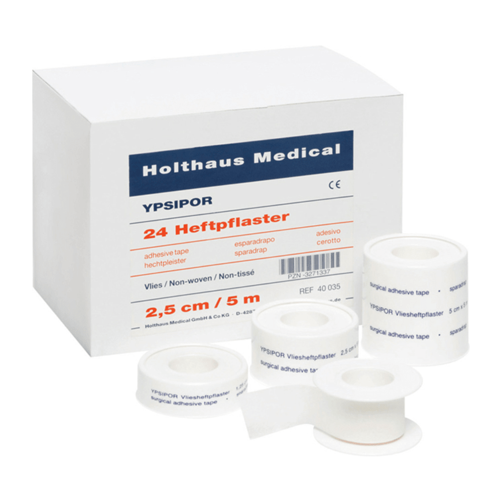 Wystawiono paczkę z napisem „Holthaus YPSIPOR Heftpflaster“ firmy Holthaus Medical GmbH & Co. KG, która zawiera 24 rolki taśmy klejącej. Na kartonie podkreślono materiał włókninowy taśmy, jej wymiary (2,5 cm x 5 m) i jej przydatność jako przyjazny dla skóry plaster. Przed kartonem ułożono kilka rolek.