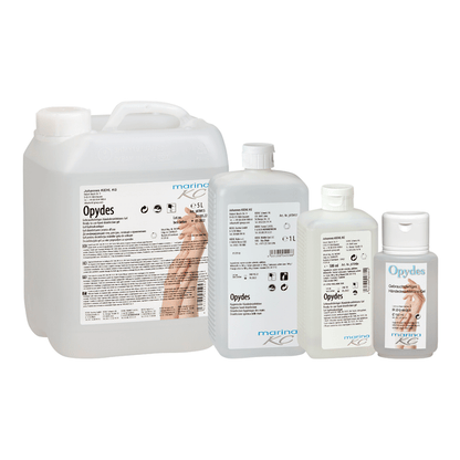 Przedstawione są cztery przezroczyste butelki Kiehl Opydes Higieniczna Dezynfekcja Rąk firmy Johannes Kiehl KG w różnych rozmiarach ustawione w rzędzie. Mają białe i niebieskie napisy z symbolami rąk do higienicznej dezynfekcji rąk i redukcji zarazków.