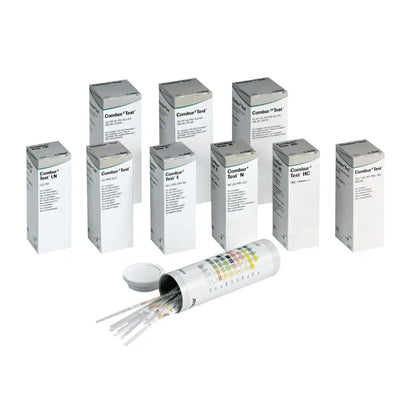 Za otwartym cylindrycznym pojemnikiem z pokrywką kryje się dziewięć pudełek z napisem „Combur®“ firmy Servoprax GmbH, z których każde zawiera 100 pasków testowych do moczu Roche. Z boku pojemnika znajduje się wielokolorowa tabela, idealna do przeprowadzania szybkiego testu.