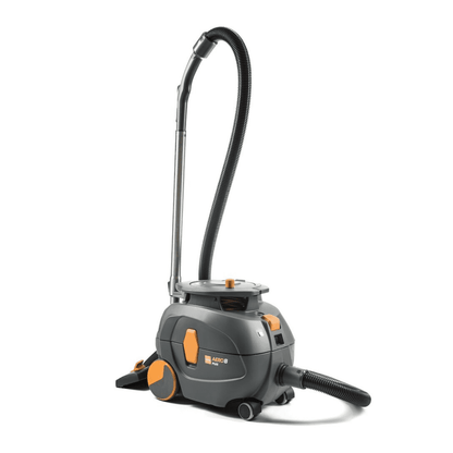 Odkurzacz TASKI AERO 8 PLUS, dostarczony przez Diversey Deutschland GmbH & Co. OHG, w kolorach szarym i pomarańczowym, stoi pionowo. Ten kompaktowy i wydajny odkurzacz posiada długi elastyczny wąż i ma cylindryczne ciało z dużymi tylnymi kołami oraz mniejszymi przednimi kołami dla doskonałej mobilności i efektywnego czyszczenia. Jego działanie jest poprawione dzięki technologii szeptu dla cichej pracy.