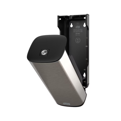 Dozownik mydła i środka dezynfekującego do rąk Tork 460010 ze stali nierdzewnej i czerni od Essity Professional Hygiene Germany GmbH do montażu na ścianie z otwartą przednią płytą, która odsłania wnętrze. Ten nowoczesny design zawiera również częściowo odłączoną płytę, która odsłania wewnętrzne mocowanie i pozycje śrub.