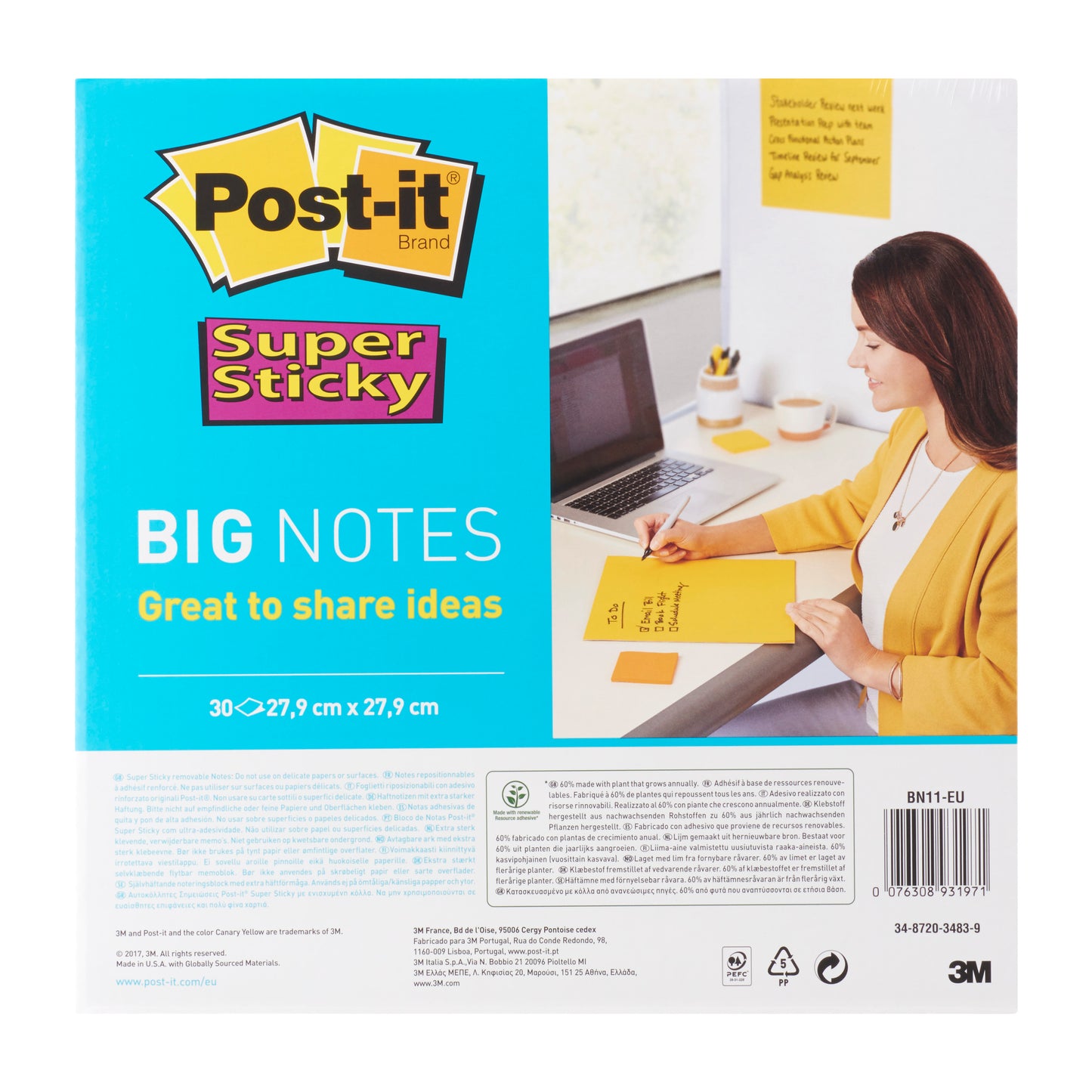 Eine Frau im gelben Blazer schreibt an ihrem Schreibtisch auf Post-it® Super Sticky Big Notes BN11-EU (279 x 279 mm, 30 Blatt, gelb) von 3M Deutschland GmbH. Die Verpackung weist auf die PEFC-Zertifizierung (SGSCH-PEFC-COC-110078) hin.