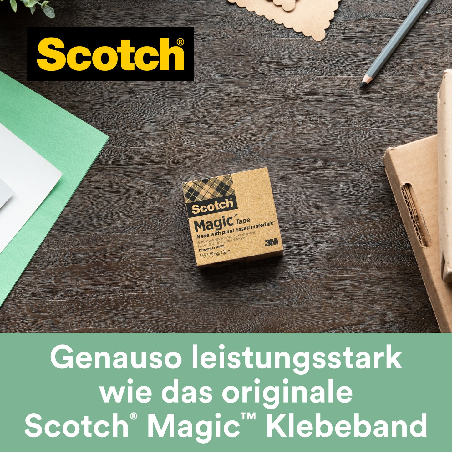 Der Scotch® C38 Tischabroller schwarz mit 3 Rollen Scotch® Magic™ Klebeband (19 mm x 33 m, 66 % pflanzlicher Klebstoff) von 3M Deutschland GmbH liegt auf einer Holzoberfläche neben Papier, Stift und Karton.