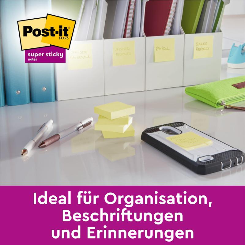 Biurko z długopisami, smartfonem i segregatorami oznaczonymi według kategorii pokazuje karteczki Post-it® Super Sticky Notes (76 mm x 76 mm, 90 arkuszy/blok) firmy 3M Deutschland GmbH, do organizacji, oznaczania i przypominania po niemiecku.