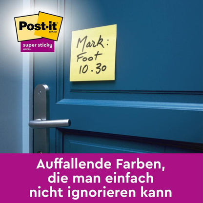 Żółta karteczka samoprzylepna Post-it® Super Sticky Note (76 mm x 76 mm, 90 arkuszy/blok) od 3M Deutschland GmbH z napisem „Mark: Foot 10.30” jest przyklejona do niebieskich drzwi. Logo jest widoczne, a niemiecki tekst podkreśla jego widoczność.