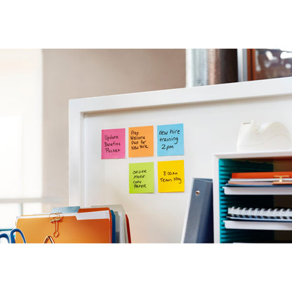 Na białej ściance biurowej stoją sześć kolorowych karteczek samoprzylepnych Post-it® Super Sticky Z-Notes (14 bloków + 2 gratis, różne kolory, 76x76 mm, 90 arkuszy/blok, od 3M Deutschland), segregatory, niebieski organizer z dokumentami i dyspenser taśmy klejącej.